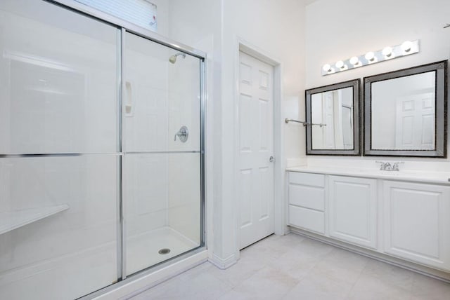 bathroom featuring a shower with door and vanity