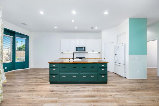 kitchen featuring a center island with sink, sink, white cabinetry, light wood-type flooring, and white refrigerator with ice dispenser