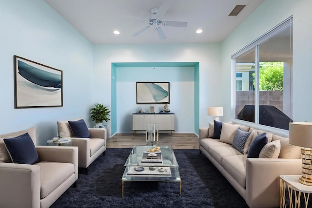 living room featuring ceiling fan and dark hardwood / wood-style floors