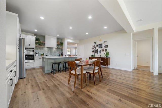 dining area featuring sink and light wood-type flooring