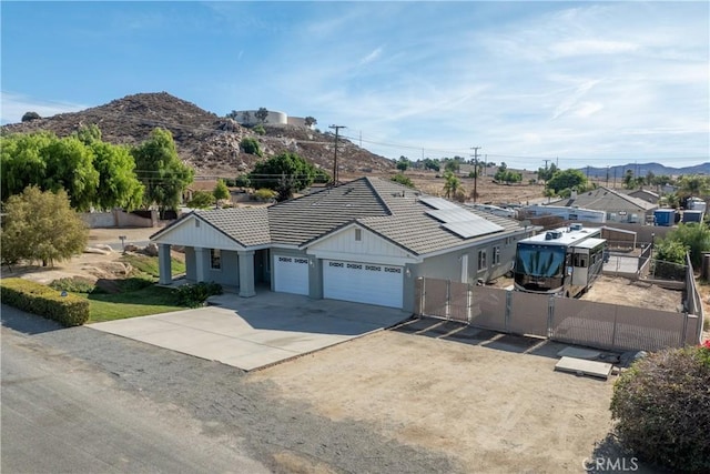 ranch-style house featuring a garage, solar panels, and a mountain view