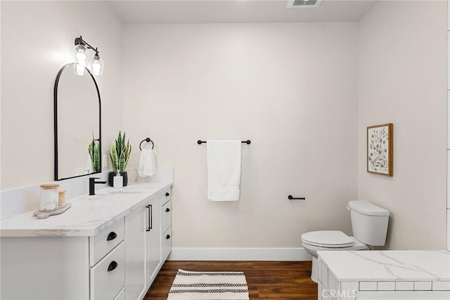 bathroom with wood-type flooring, toilet, and vanity