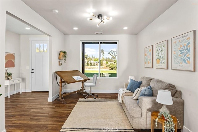 living room with dark hardwood / wood-style floors and an inviting chandelier