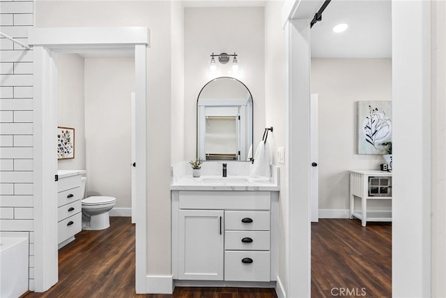 bathroom with toilet, vanity, and hardwood / wood-style flooring