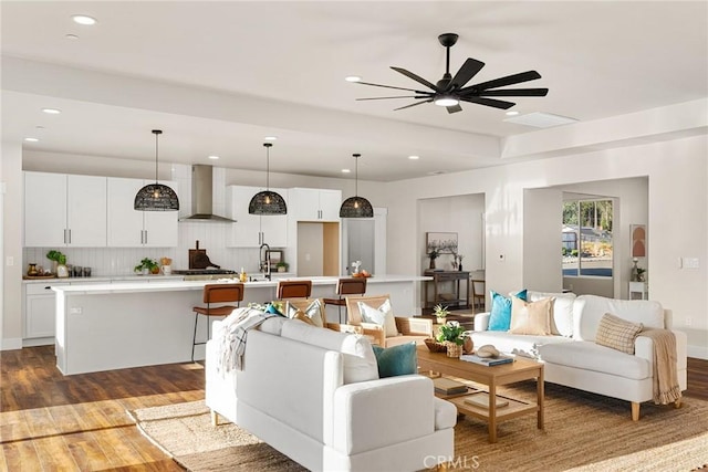 living room with ceiling fan, dark hardwood / wood-style flooring, and sink