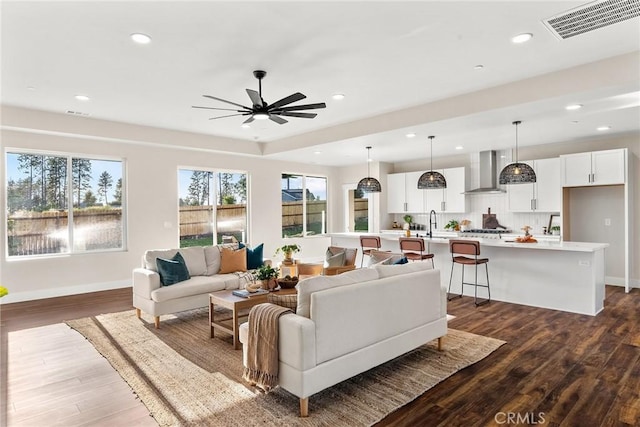 living room with ceiling fan, dark hardwood / wood-style flooring, and sink