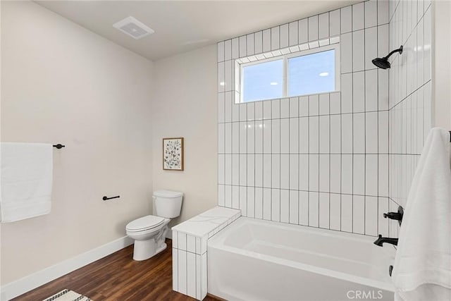 bathroom with toilet, tub / shower combination, and hardwood / wood-style floors