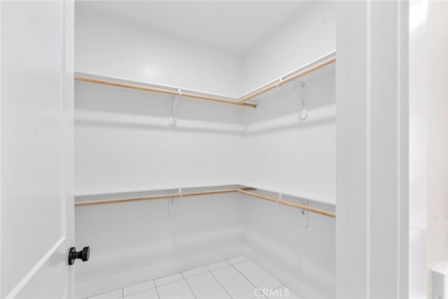 walk in closet with light tile patterned floors