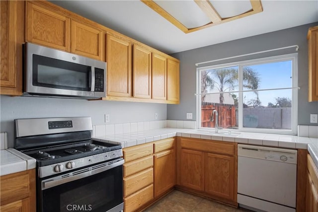 kitchen featuring tile counters, sink, and stainless steel appliances