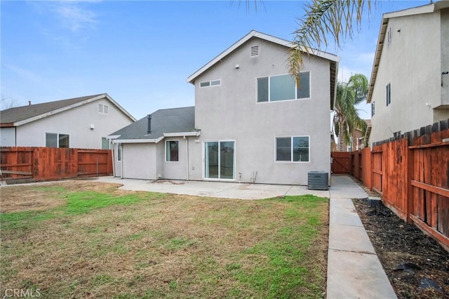 rear view of property featuring a lawn, cooling unit, and a patio