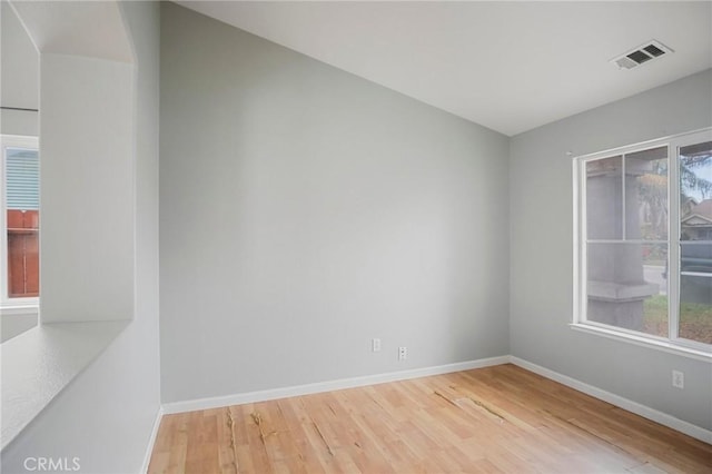 unfurnished room with a healthy amount of sunlight and wood-type flooring