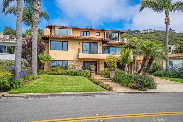 view of front of property with a front lawn and a balcony