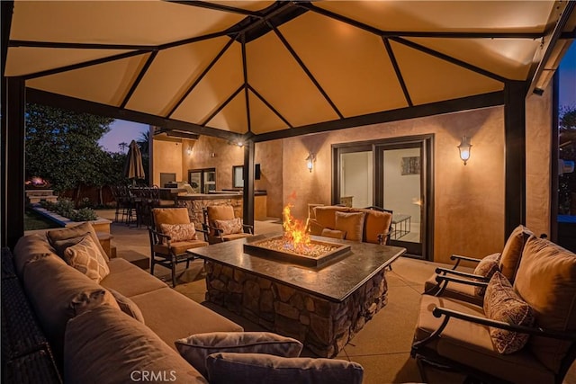 patio terrace at dusk with an outdoor living space with a fire pit