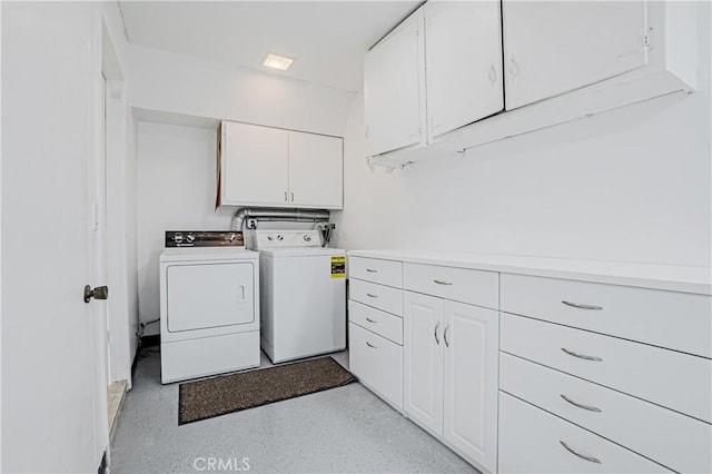 clothes washing area with washer and dryer and cabinets