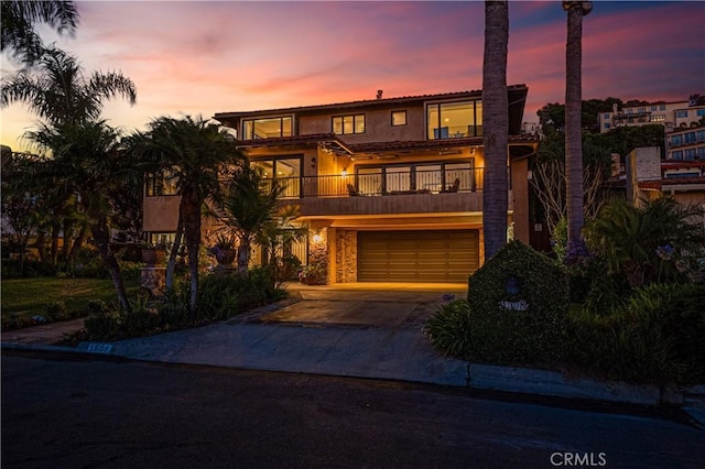 view of front of home featuring a garage and a balcony