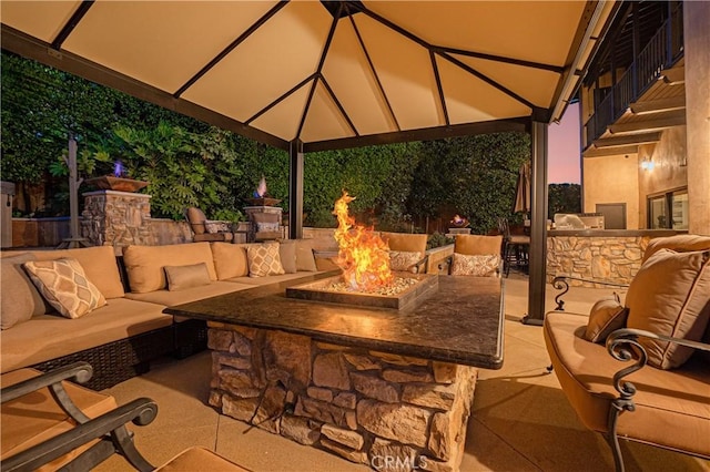 view of patio with an outdoor living space with a fire pit and a gazebo