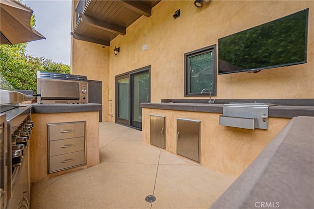 view of patio with an outdoor kitchen and sink