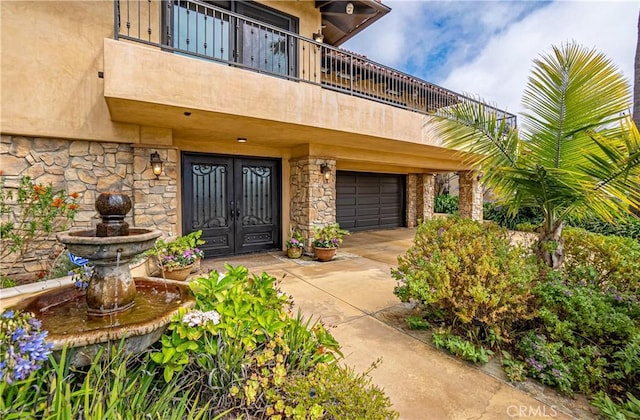 view of exterior entry with french doors and a garage