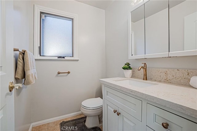 bathroom with toilet, tile patterned floors, and vanity