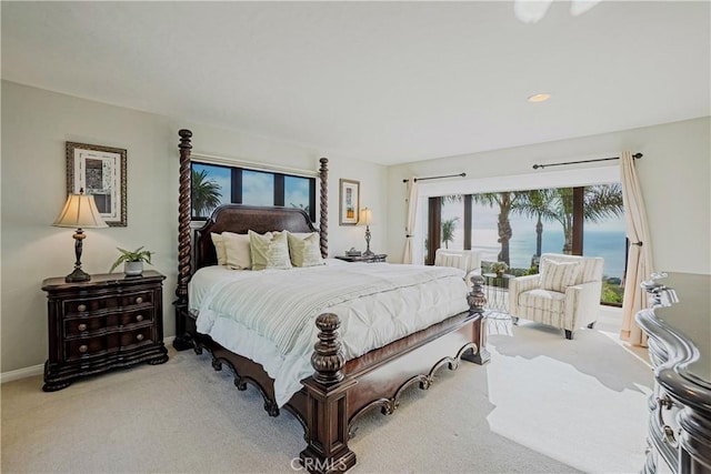 bedroom with carpet floors and a water view