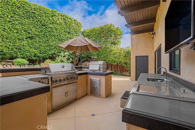 view of patio / terrace with an outdoor kitchen, sink, and area for grilling