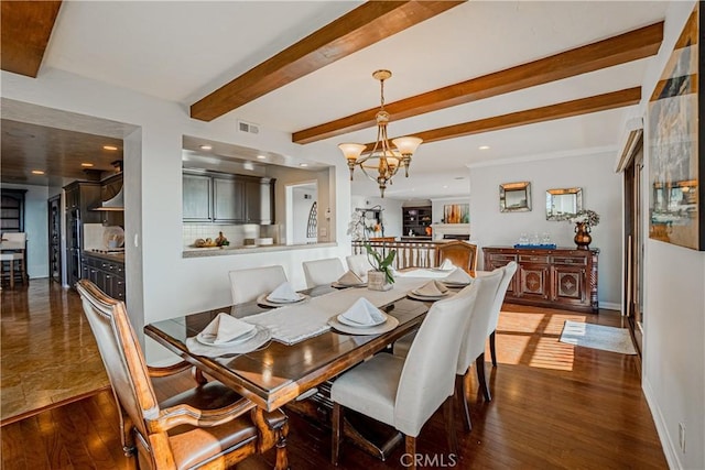 dining room with dark hardwood / wood-style flooring, beamed ceiling, and an inviting chandelier