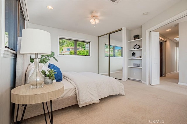 bedroom featuring ceiling fan, a closet, and light carpet