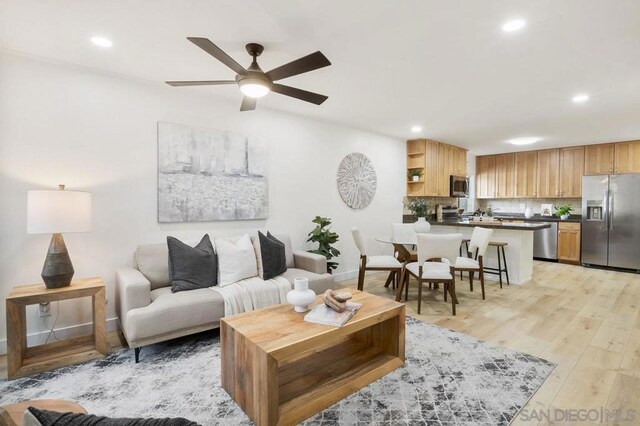 living room featuring ceiling fan and light hardwood / wood-style flooring