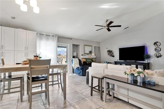 tiled living room featuring ceiling fan and vaulted ceiling