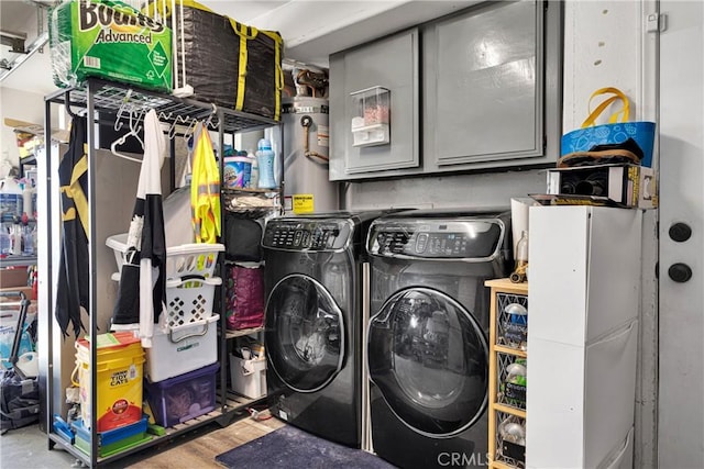 laundry room with independent washer and dryer, secured water heater, and cabinets