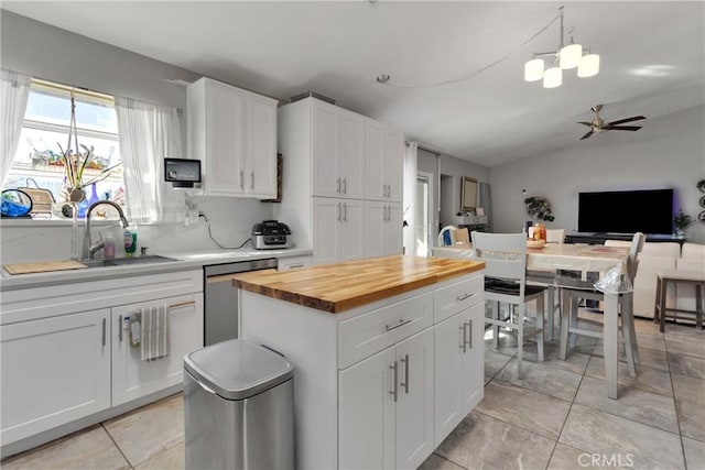 kitchen with vaulted ceiling, dishwasher, and white cabinets