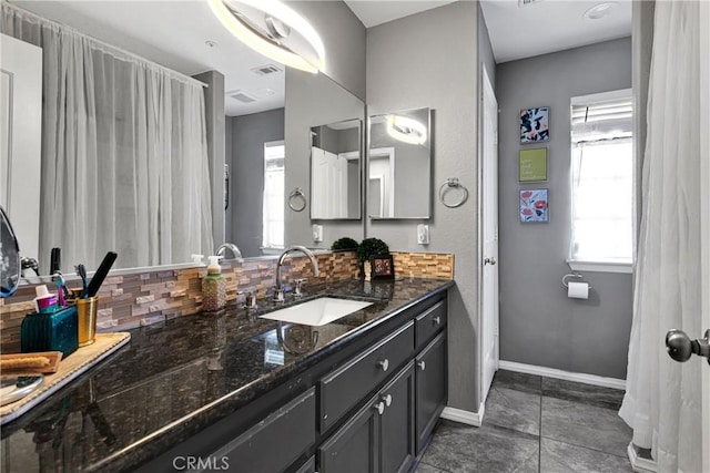 bathroom featuring decorative backsplash, tile patterned floors, and vanity