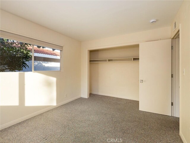 unfurnished bedroom with carpet floors and a closet