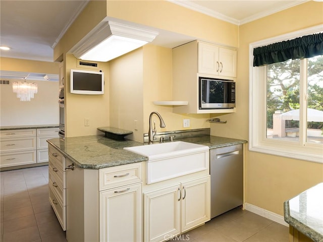 kitchen featuring white cabinets, appliances with stainless steel finishes, dark stone countertops, sink, and light tile patterned floors