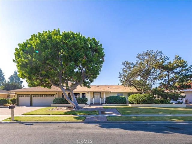 ranch-style home with a garage and a front lawn