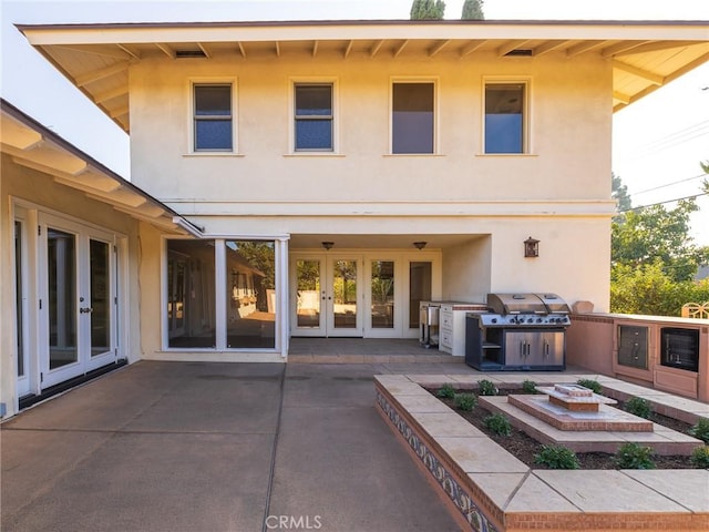 rear view of house with a patio area and french doors