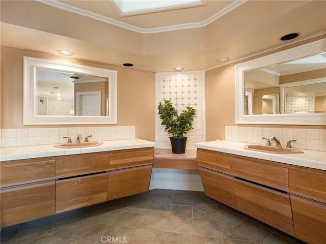 bathroom featuring tile patterned flooring, vanity, backsplash, and crown molding