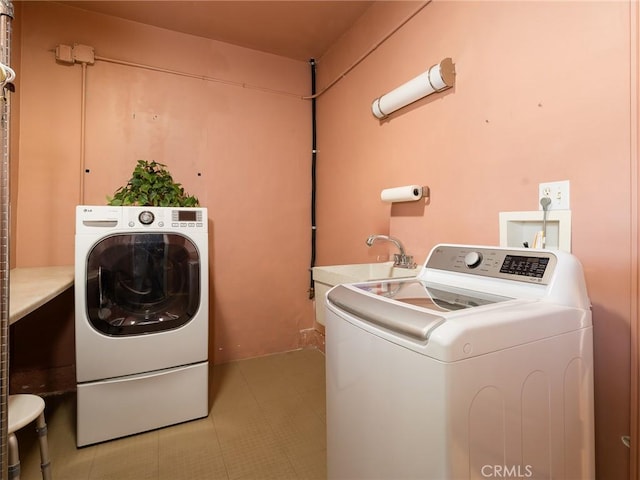 washroom with washing machine and clothes dryer and sink