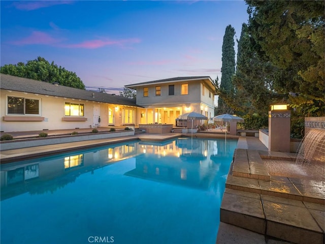 pool at dusk with a patio