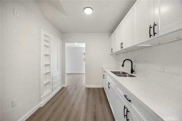 kitchen featuring white cabinets, light hardwood / wood-style flooring, and sink