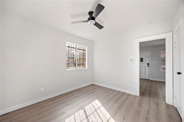 empty room with ceiling fan and light hardwood / wood-style flooring