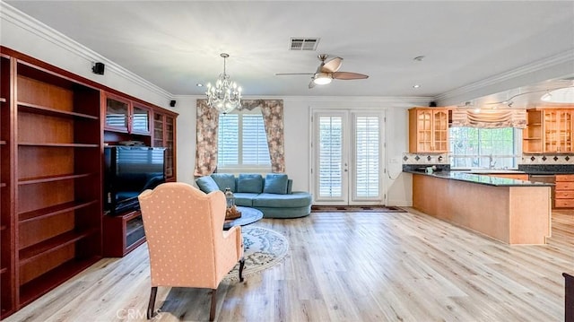 living room with sink, ceiling fan with notable chandelier, ornamental molding, and light wood-type flooring