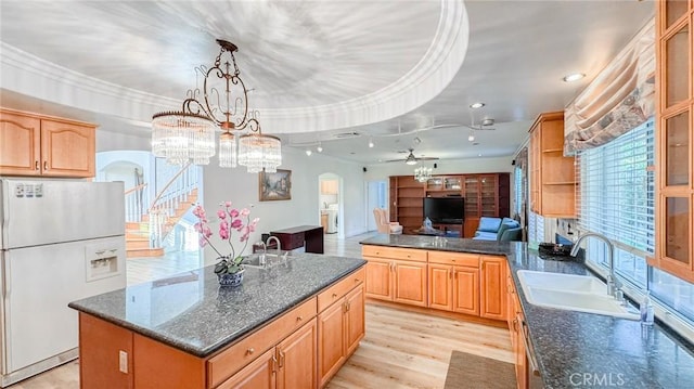 kitchen with sink, decorative light fixtures, a center island, light wood-type flooring, and white fridge with ice dispenser