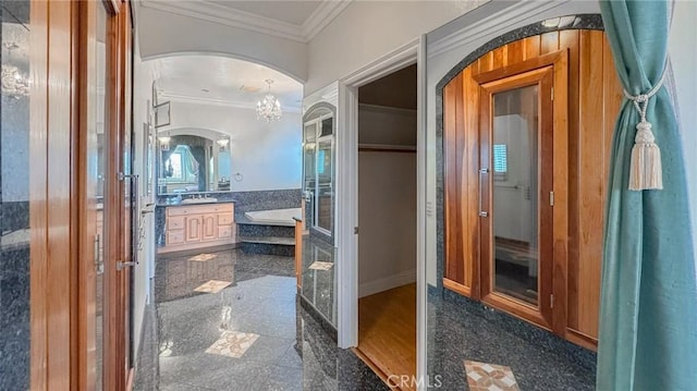 bathroom featuring ornamental molding, a bath, and vanity