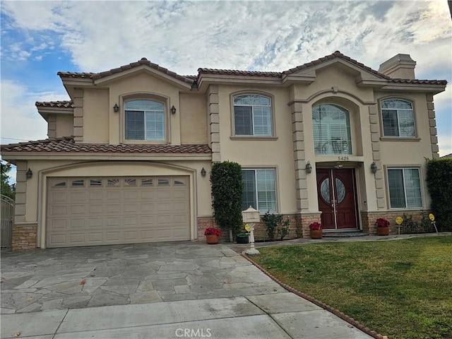 mediterranean / spanish-style house with a garage and a front yard