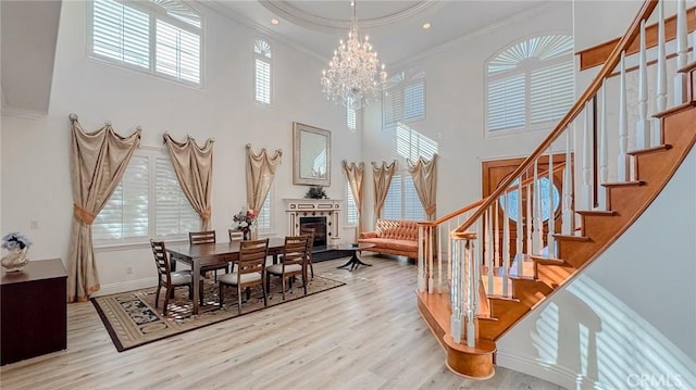 dining space with ornamental molding, a wealth of natural light, a chandelier, and light wood-type flooring