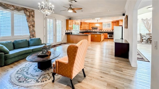 living room with light hardwood / wood-style flooring, sink, crown molding, and a wealth of natural light