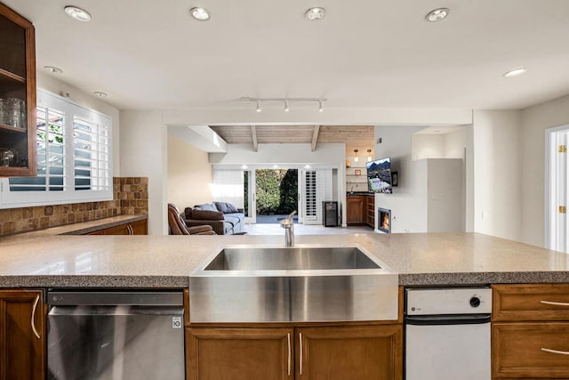 kitchen featuring wood ceiling, rail lighting, beamed ceiling, stainless steel dishwasher, and sink