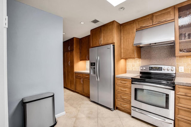 kitchen featuring light tile patterned floors, backsplash, and appliances with stainless steel finishes