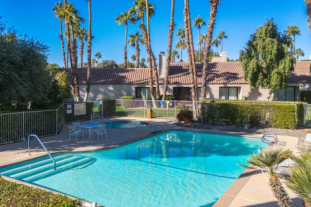 view of swimming pool featuring a patio area and a hot tub